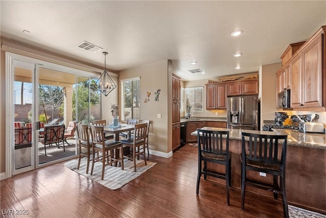 dining room with baseboards, visible vents, dark wood finished floors, and a chandelier