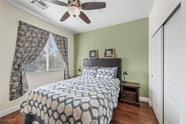 bedroom with a closet, visible vents, baseboards, and wood finished floors