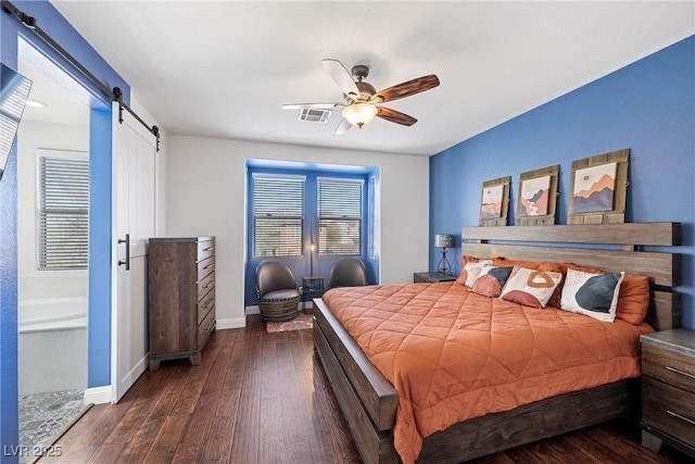 bedroom featuring a barn door, visible vents, baseboards, a ceiling fan, and wood-type flooring