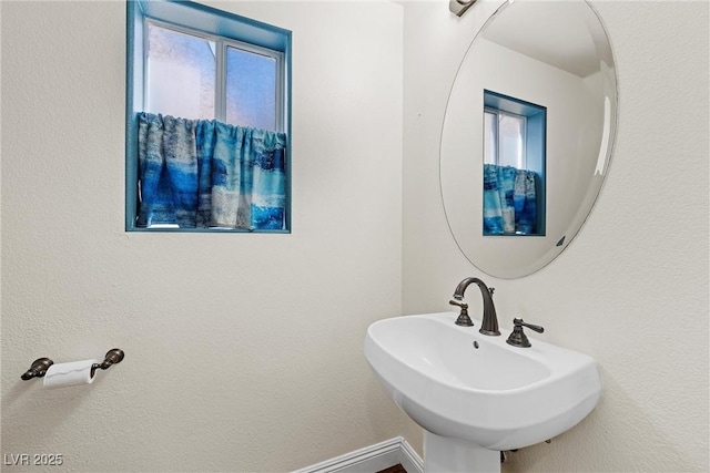 bathroom with baseboards and a sink