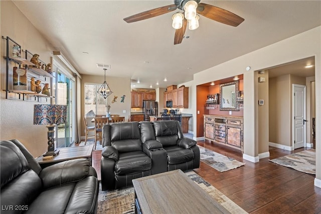 living area with dark wood-style flooring, visible vents, and baseboards