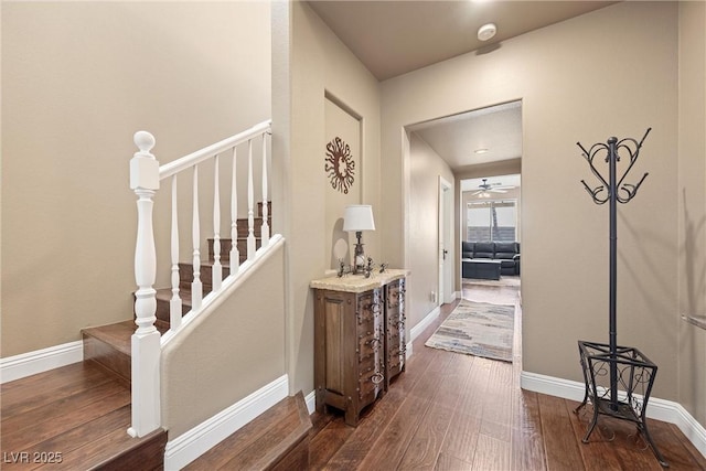 hallway featuring dark wood-style floors, stairs, and baseboards