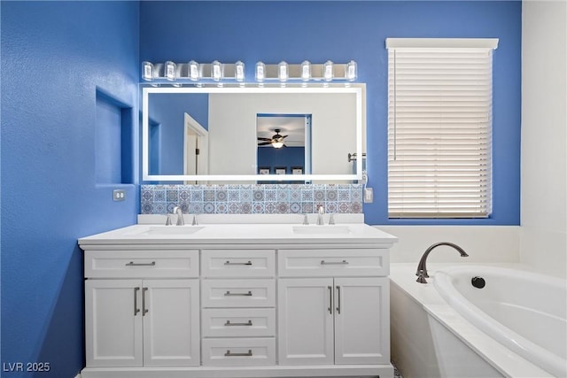 bathroom featuring a garden tub, a sink, decorative backsplash, and double vanity