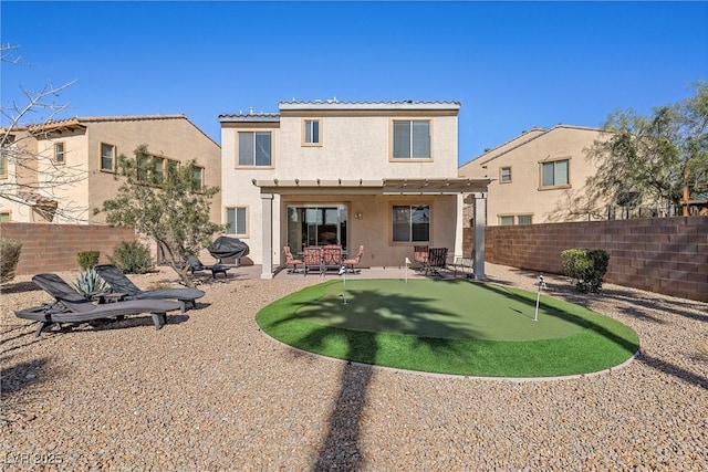 rear view of house with a patio area, a fenced backyard, and stucco siding