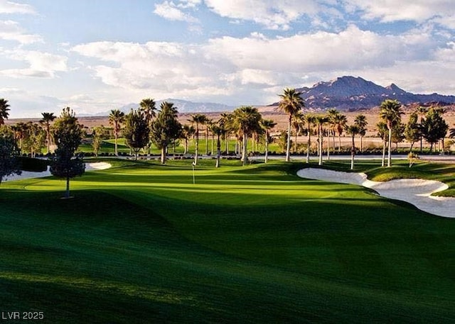 view of community featuring a mountain view, golf course view, and a lawn