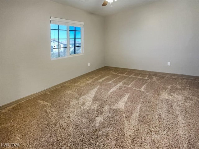 spare room featuring carpet, a ceiling fan, and baseboards