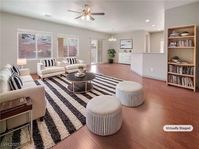 living area with recessed lighting, baseboards, visible vents, wood finished floors, and ceiling fan with notable chandelier