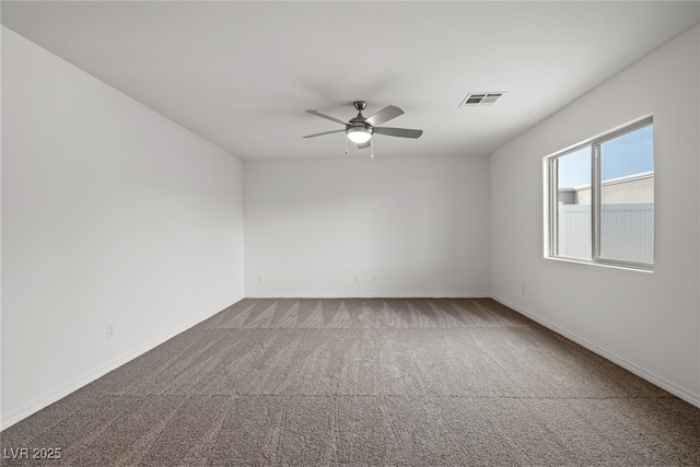 empty room with baseboards, ceiling fan, visible vents, and carpet flooring