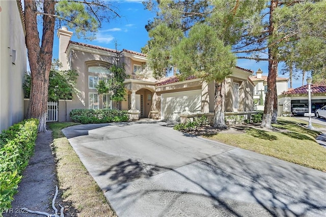 mediterranean / spanish house featuring stucco siding, driveway, a tile roof, a garage, and a chimney