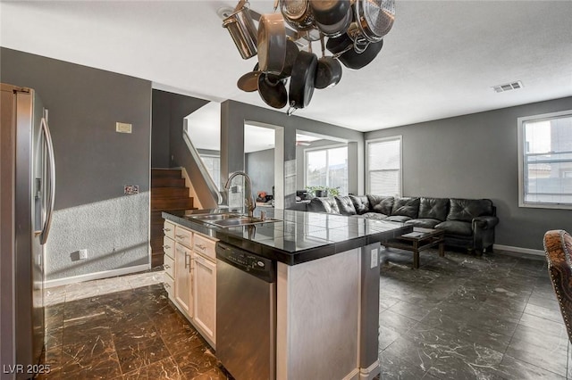 kitchen featuring stainless steel appliances, a sink, visible vents, open floor plan, and an island with sink