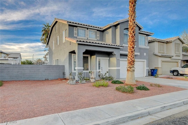 view of front of property with concrete driveway, an attached garage, fence, and stucco siding