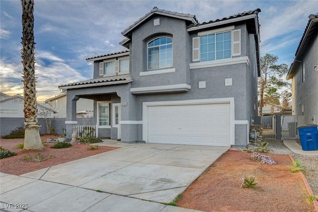 view of front facade featuring a garage, fence, and stucco siding