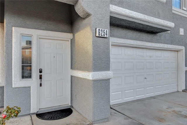 doorway to property featuring stucco siding