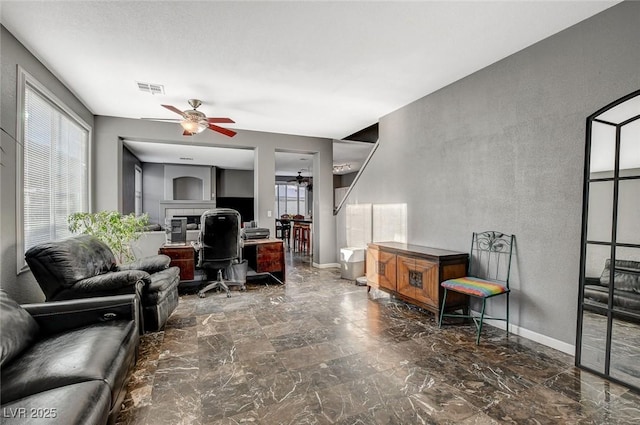 office area with marble finish floor, baseboards, visible vents, and ceiling fan