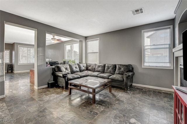 living room featuring visible vents, ceiling fan, and baseboards