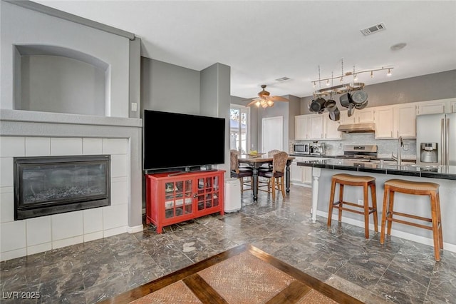 kitchen with visible vents, dark countertops, appliances with stainless steel finishes, marble finish floor, and a sink