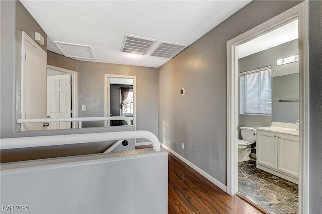 bathroom with baseboards, vanity, toilet, and wood finished floors