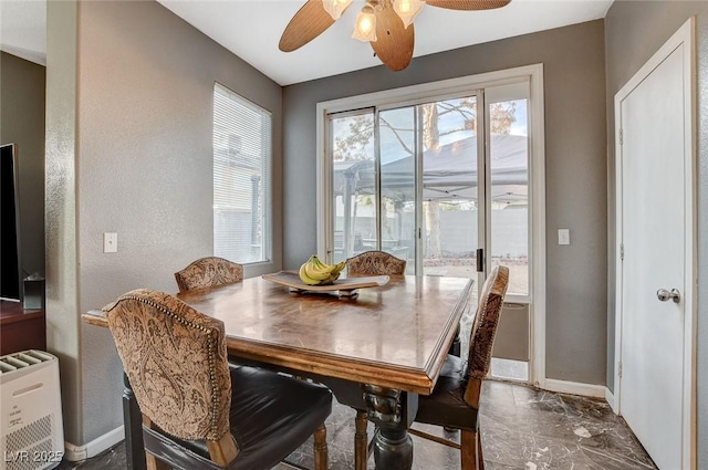 dining room with a ceiling fan and baseboards