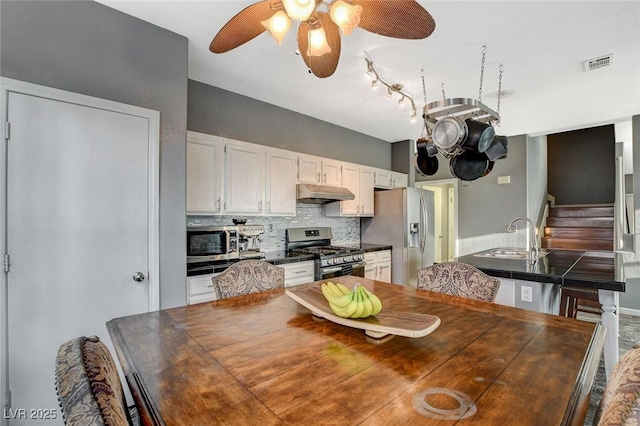 dining area with a ceiling fan, visible vents, and stairway