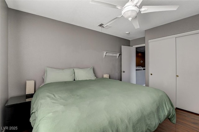 bedroom featuring ceiling fan, a closet, visible vents, and wood finished floors