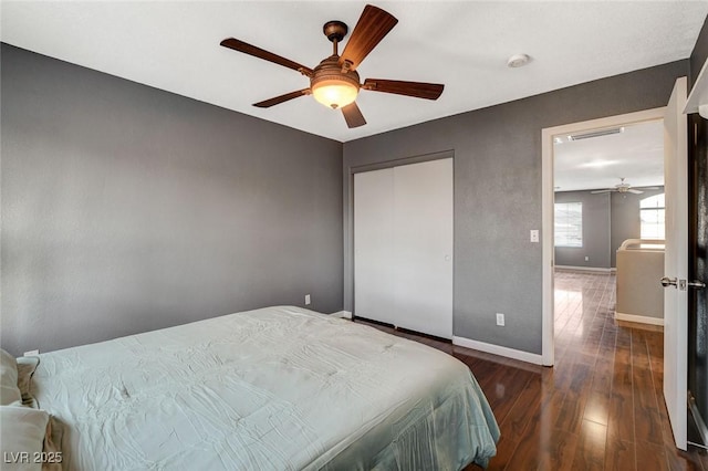 bedroom featuring ceiling fan, baseboards, and wood finished floors