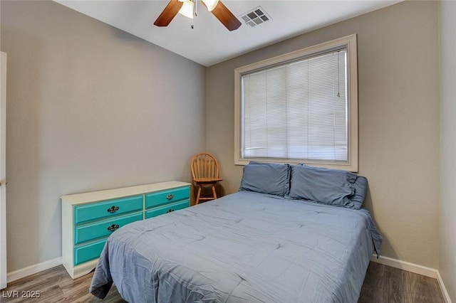 bedroom featuring baseboards, visible vents, ceiling fan, and wood finished floors