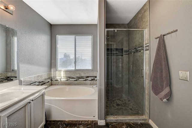 bathroom featuring a stall shower, marble finish floor, a garden tub, and vanity