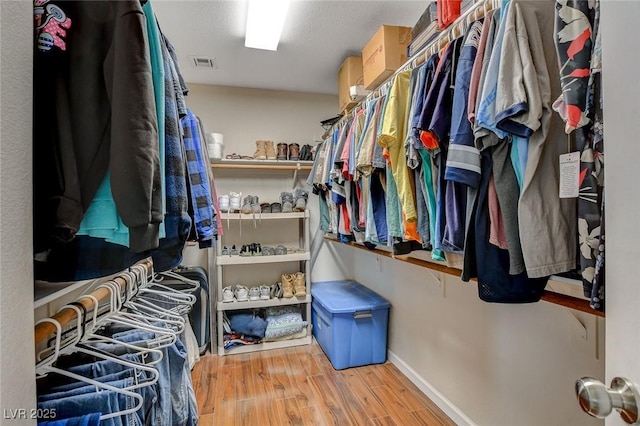 walk in closet featuring visible vents and wood finished floors