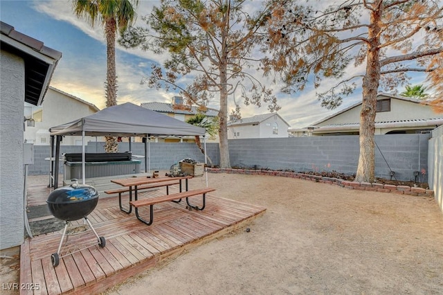 view of yard with a deck, a gazebo, a fenced backyard, and a hot tub