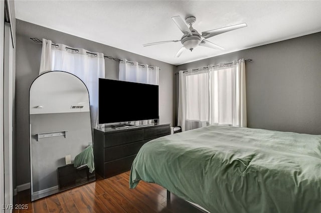 bedroom featuring ceiling fan, visible vents, and dark wood-style flooring