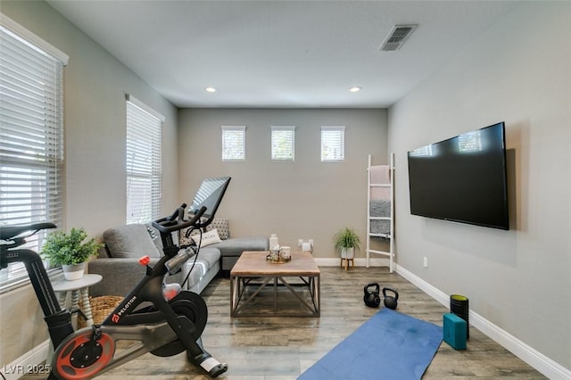 exercise room featuring recessed lighting, visible vents, baseboards, and wood finished floors