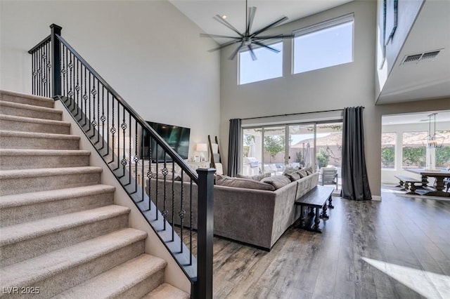 living room with a healthy amount of sunlight, an inviting chandelier, visible vents, and wood finished floors