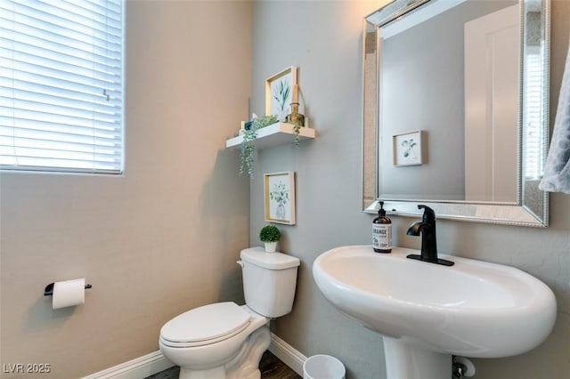 bathroom with toilet, baseboards, and a sink