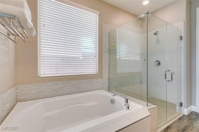 full bath with a garden tub, a shower stall, and wood finished floors