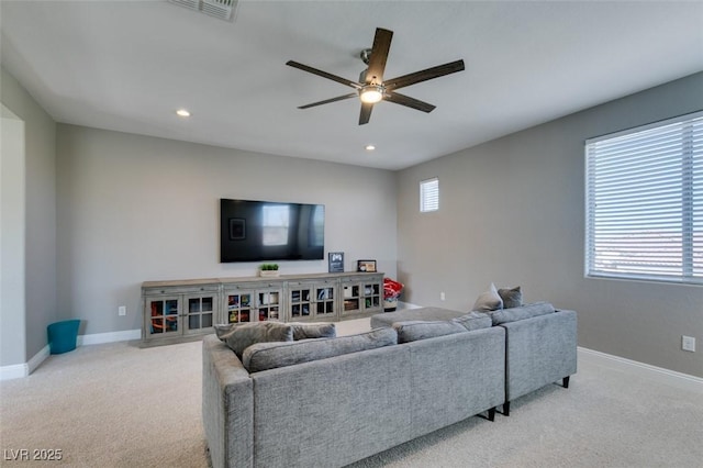 living area with light carpet, plenty of natural light, and baseboards