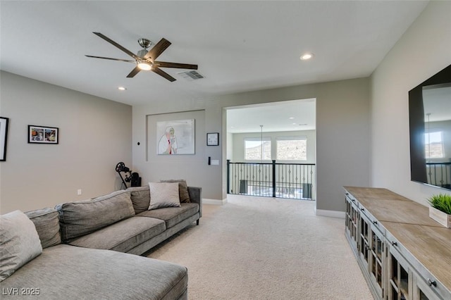 living area with recessed lighting, visible vents, baseboards, and light colored carpet