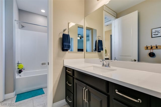 bathroom featuring tile patterned floors, bathtub / shower combination, baseboards, and vanity