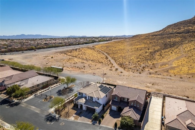 drone / aerial view featuring a desert view and a mountain view