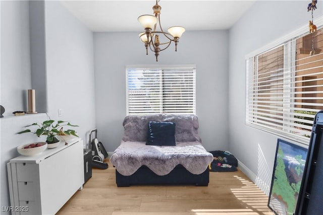 sitting room featuring baseboards, light wood-style flooring, and an inviting chandelier