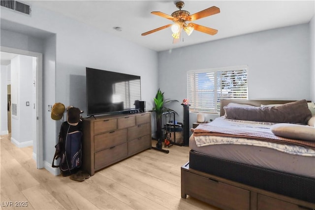 bedroom featuring a ceiling fan, light wood-type flooring, visible vents, and baseboards