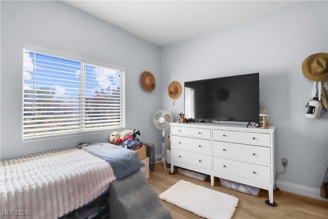 bedroom featuring light wood-style floors and baseboards