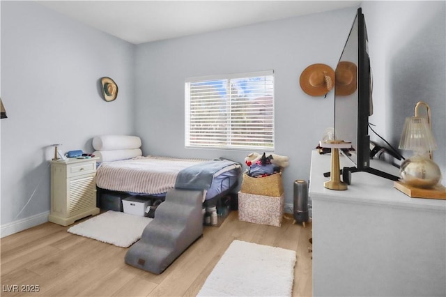 bedroom with wood finished floors and baseboards