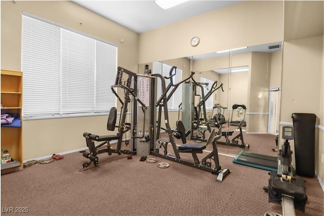 exercise room with visible vents and baseboards