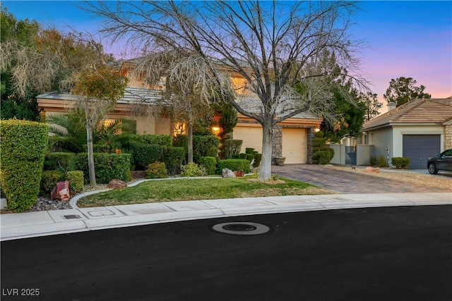 view of property hidden behind natural elements with driveway, an attached garage, and stucco siding