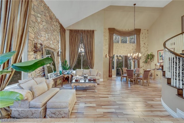 living area featuring a healthy amount of sunlight, stairway, a chandelier, and high vaulted ceiling