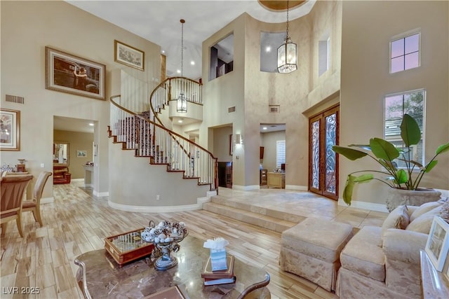 foyer entrance with stairway, wood finished floors, visible vents, and baseboards