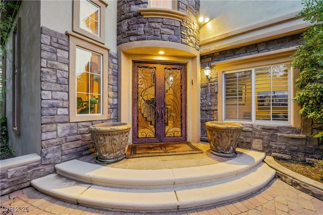 property entrance featuring stone siding and french doors