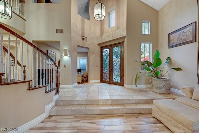 foyer with french doors, visible vents, stairway, wood finished floors, and baseboards