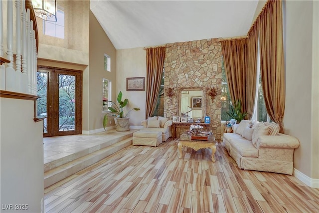 interior space with high vaulted ceiling, french doors, plenty of natural light, and wood finished floors