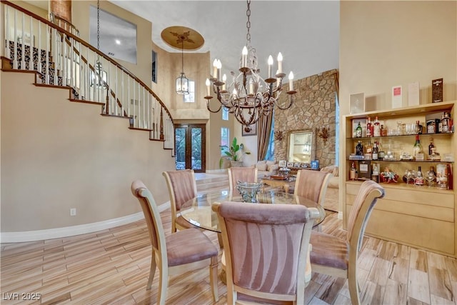 dining room with a notable chandelier, a high ceiling, and wood finished floors